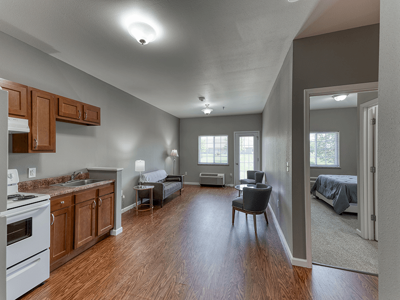 An apartment living room and kitchenette with accessible layouts and senior-friendly features at Cedarhurst of Breese