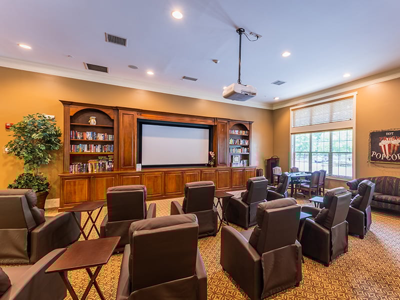 A comfortable and accessible movie theater at Cedarhurst of Canton, featuring a large screen and plush seating for residents' enjoyment