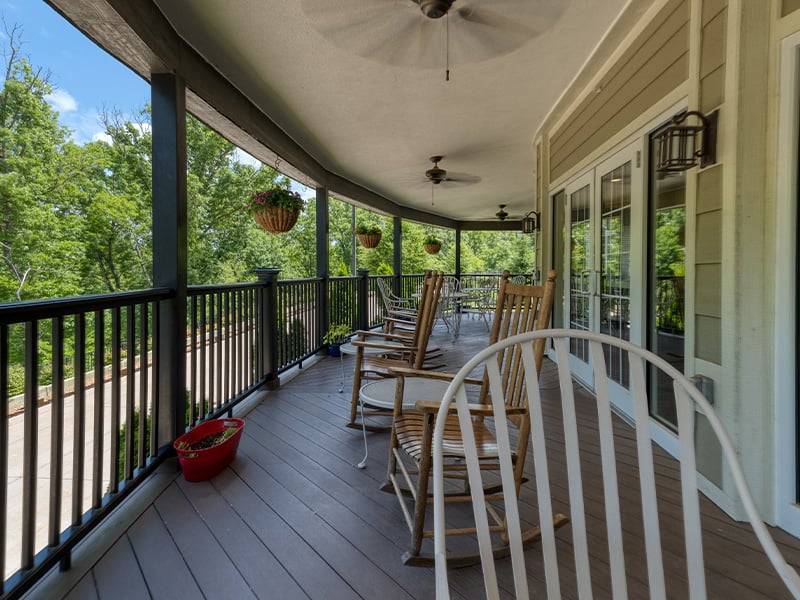 An accessible covered porch equipped with rocking chairs and fans
