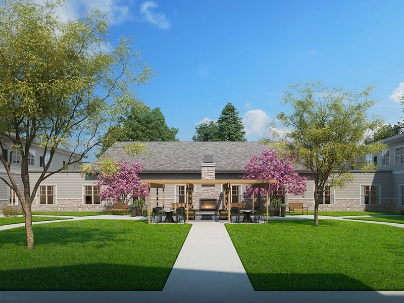 Outdoor green space at Cedarhurst of Crown Point with paved walking paths, a wooden pergola, and fireplace