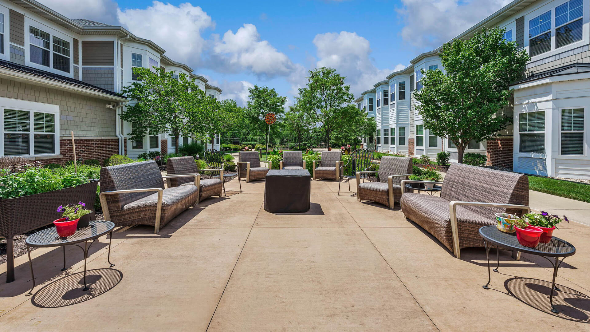 An outdoor shaded patio with comfortable seating at Cedarhurst of Des Peres