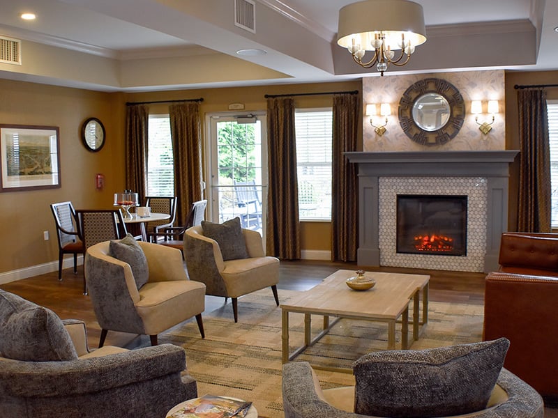 Welcoming common area at Cedarhurst of Des Peres, complete with comfortable furniture and a warm fireplace for relaxation and socialization