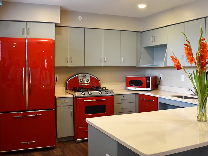 Senior-accessible diner and diner and kitchen at Cedarhurst of Des Peres offering ample seating—perfect for dining and gathering