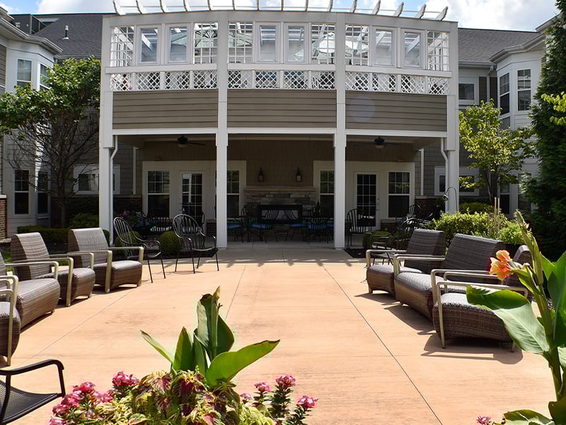 An outdoor shaded patio with comfortable seating at Cedarhurst of Des Peres