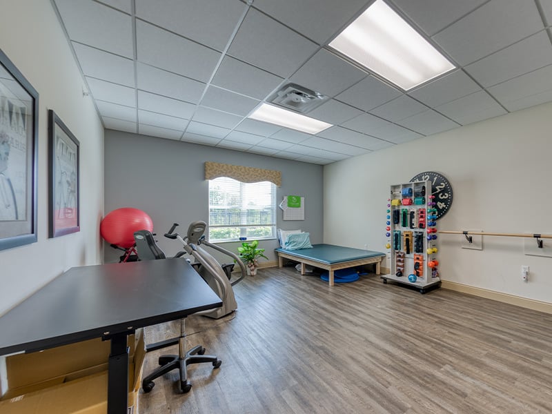The dedicated physical therapy room at Cedarhurst of Des Peres, equipped with accessible equipment for resident rehabilitation and wellness