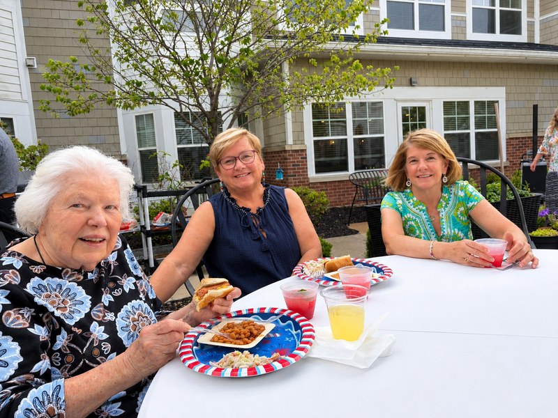  Assisted living residents and guests enjoying a cookout in the courtyard.