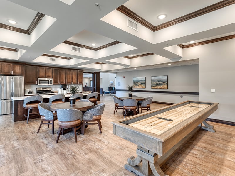 A fun-filled common area at Cedarhurst of Dyer, offering residents entertainment with game tables and a shuffleboard setup