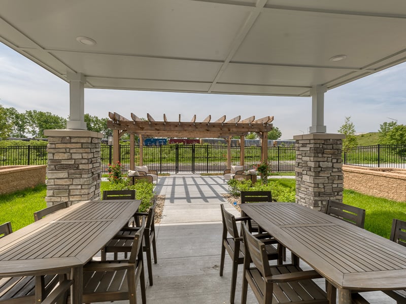 An outdoor shaded patio with comfortable seating at Cedarhurst of Dyer