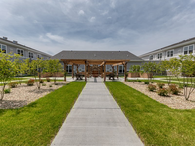 An inviting outdoor patio space with a wooden pergola at the Cedarhurst of Dyer senior living community