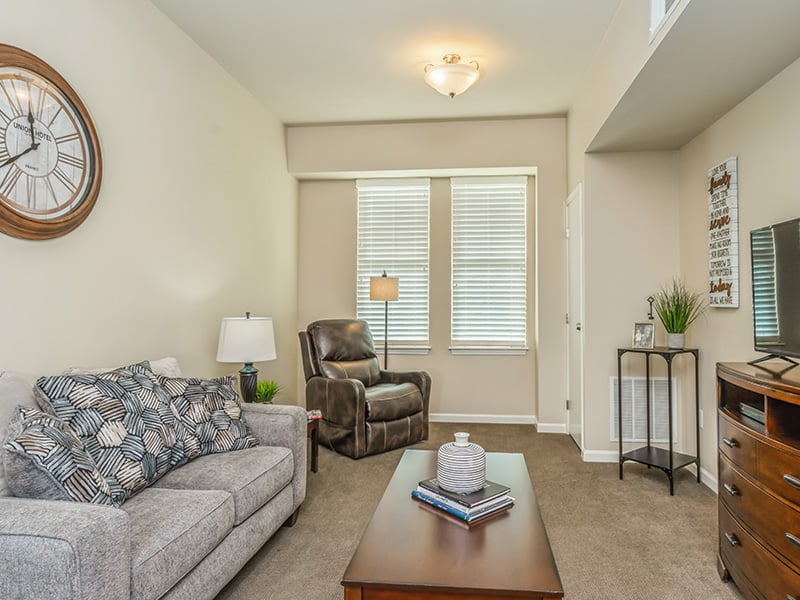 A spacious and bright living room inside a senior apartment at Cedarhurst of East Louisville