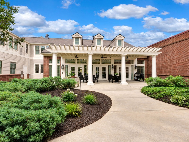 Outdoor green space at Cedarhurst of East Louisvillewith paved walking paths and raised garden beds