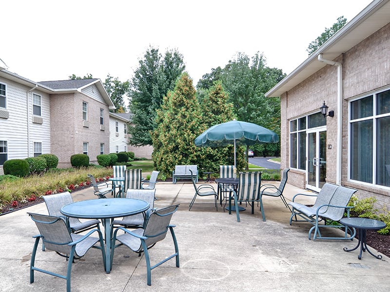 Outdoor shaded patio with comfortable seating at Cedarhurst of Edison Lakes