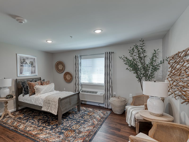 A cozy and well-appointed senior apartment bedroom at Cedarhurst of Farmington
