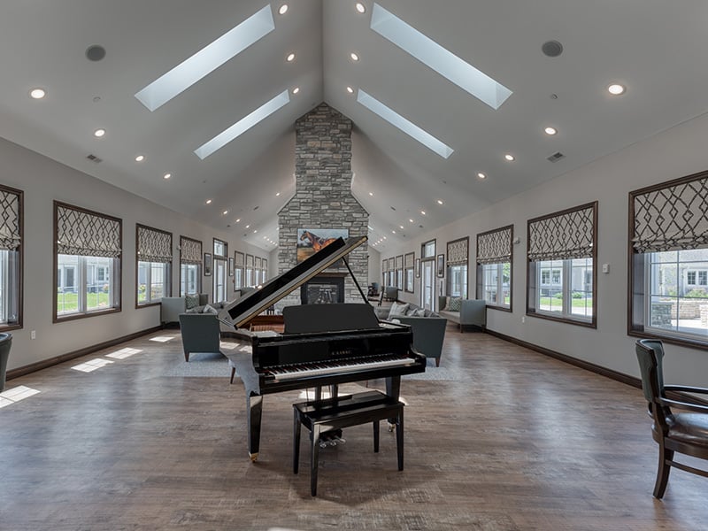 Cedarhurst of Farmington common area with comfortable seating, a fireplace, and a piano