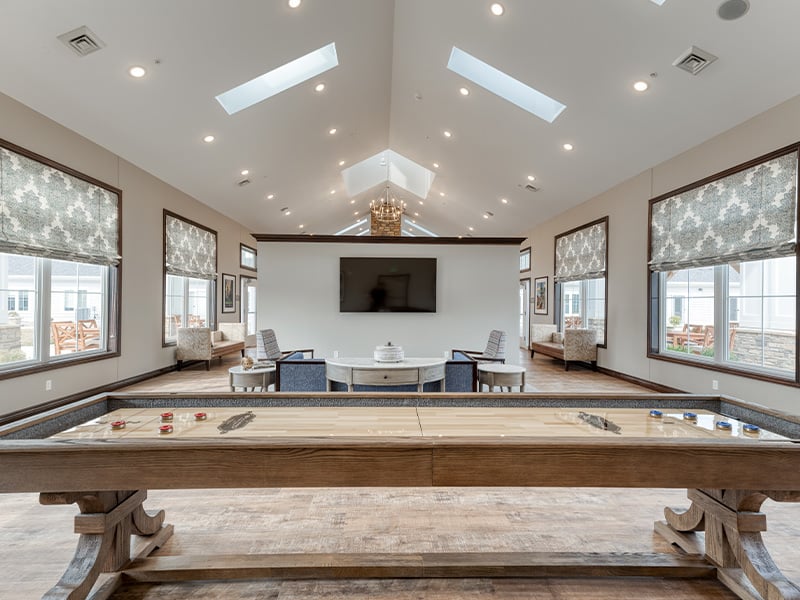 Cedarhurst of Fort Wayne's welcoming common area, complete with comfortable furniture, tv and a shuffleboard table for relaxation and socialization