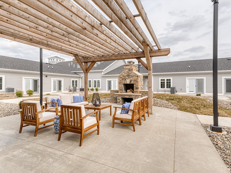 An inviting outdoor patio space with a wooden pergola at the Cedarhurst of Fort Wayne senior living community