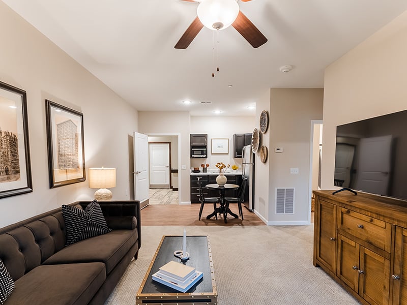 An apartment living room and kitchenette featuring accessible layouts and senior-friendly features at Cedarhurst of Frankfort