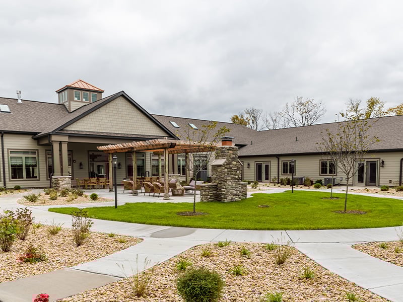 Outdoor lawn and patio area with a pergola at the Cedarhurst of Frankfort senior living community