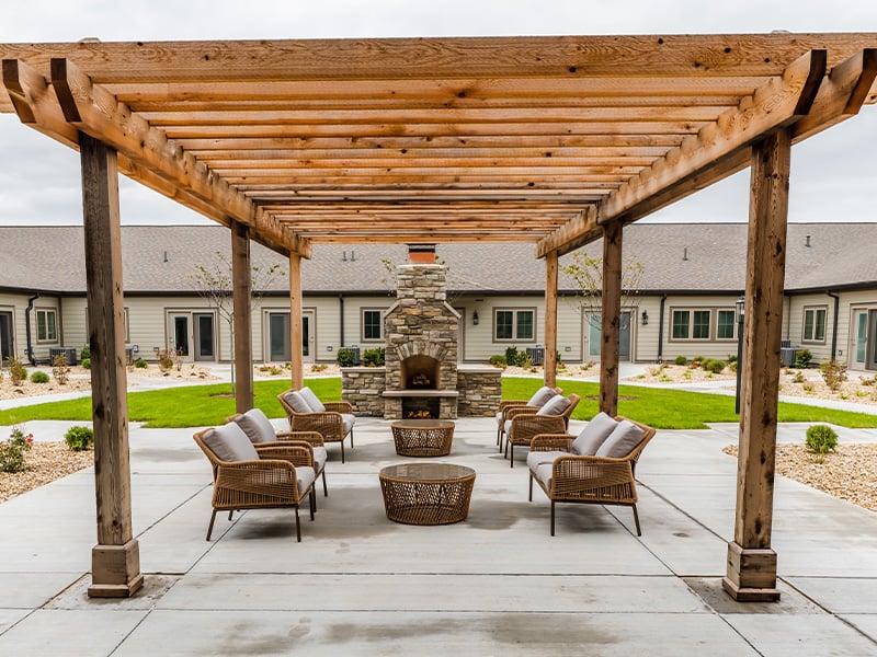 An inviting outdoor patio space with a wooden pergola at the Cedarhurst of Frankfort senior living community