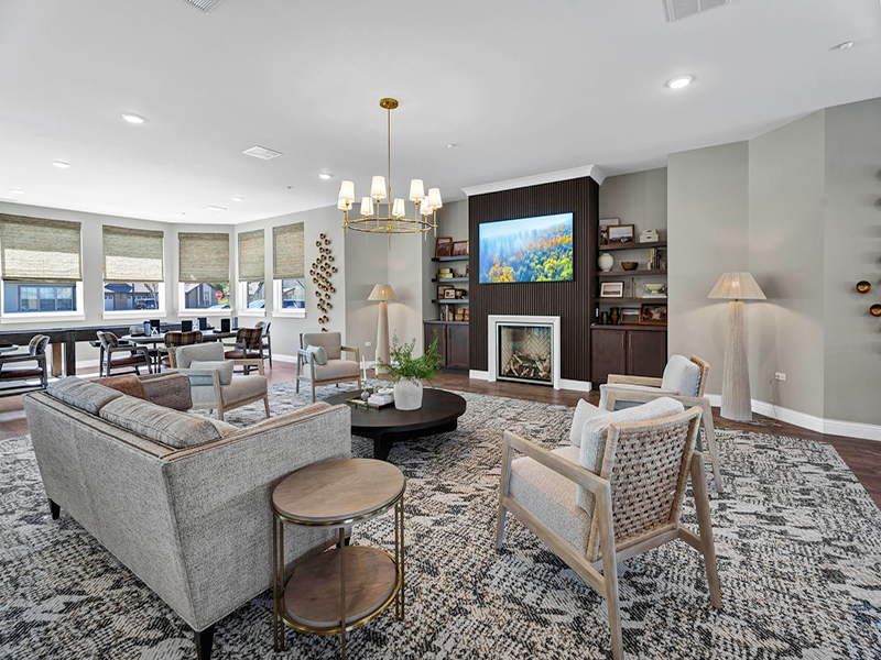 A cozy clubhouse lounge at Cedarhurst of Frankfort, offering comfortable sofas and armchairs for independent living residents to gather and visit