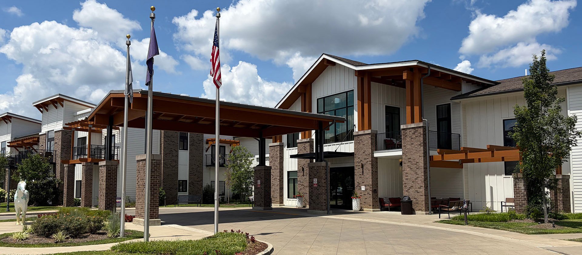 An inviting view of the Cedarhurst of Hamburg senior living community from the outside, complete with the main building.