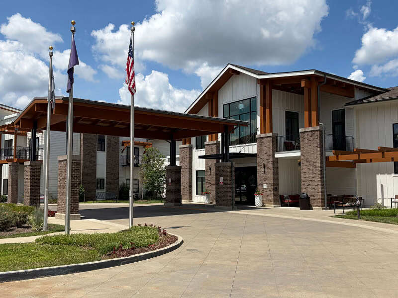 An inviting view of the Cedarhurst of Hamburg senior living community from the outside, complete with the main building.