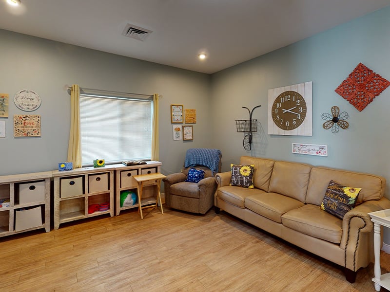 An apartment living room and kitchenette featuring accessible layouts and senior-friendly features at Cedarhurst of Highland