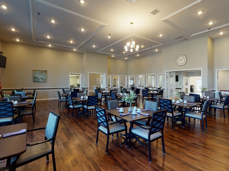 A spacious and bright dining room at Cedarhurst of Highland, offering comfortable seating for meals
