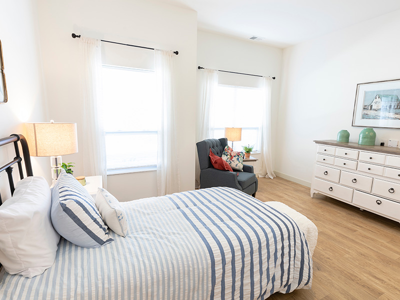 A cozy and well-appointed senior apartment bedroom for residents at Cedarhurst of La Vista
