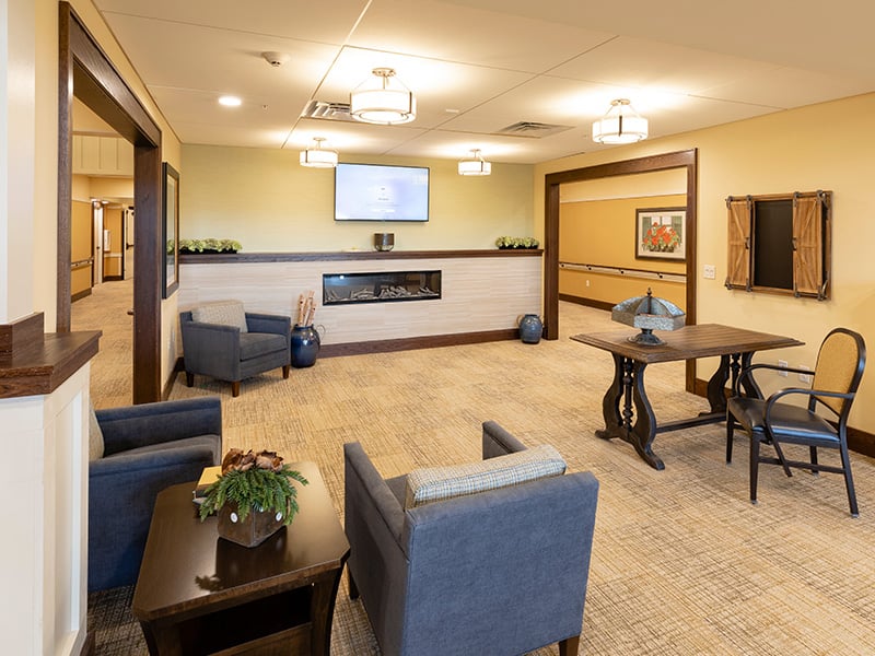 A welcoming common area at Cedarhurst of La Vista, featuring ample seating and a television, perfect for relaxation or watching programs