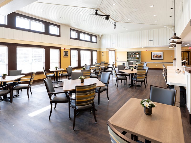 A spacious and bright dining room at Cedarhurst of La Vista, offering comfortable seating for meals