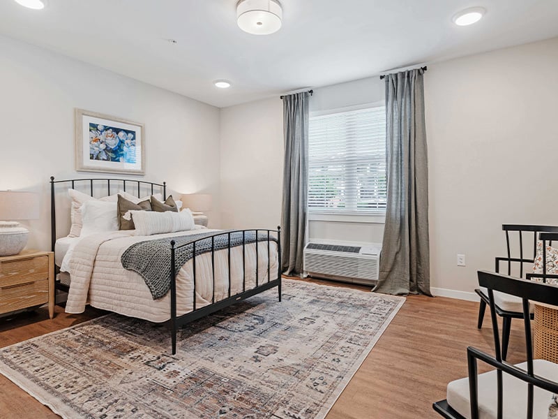 A cozy and well-appointed senior apartment bedroom for residents at Cedarhurst of Lawrence