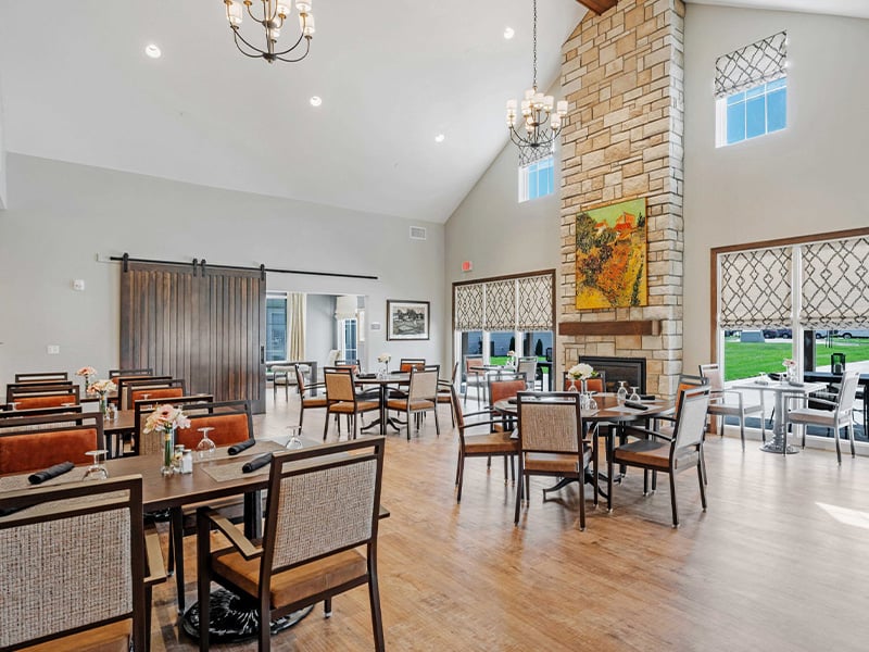 A spacious and bright dining room at Cedarhurst of Lawrence, offering comfortable seating for meals.