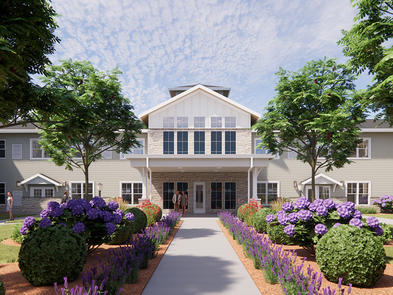 Outdoor green space at Cedarhurst of Lincoln with paved walking paths and garden beds