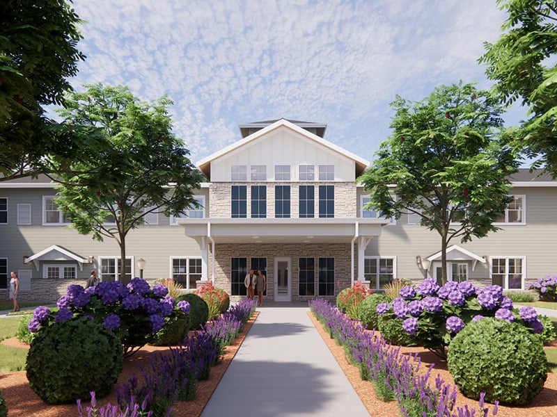 Outdoor green space at Cedarhurst of Lincoln with paved walking paths and garden beds