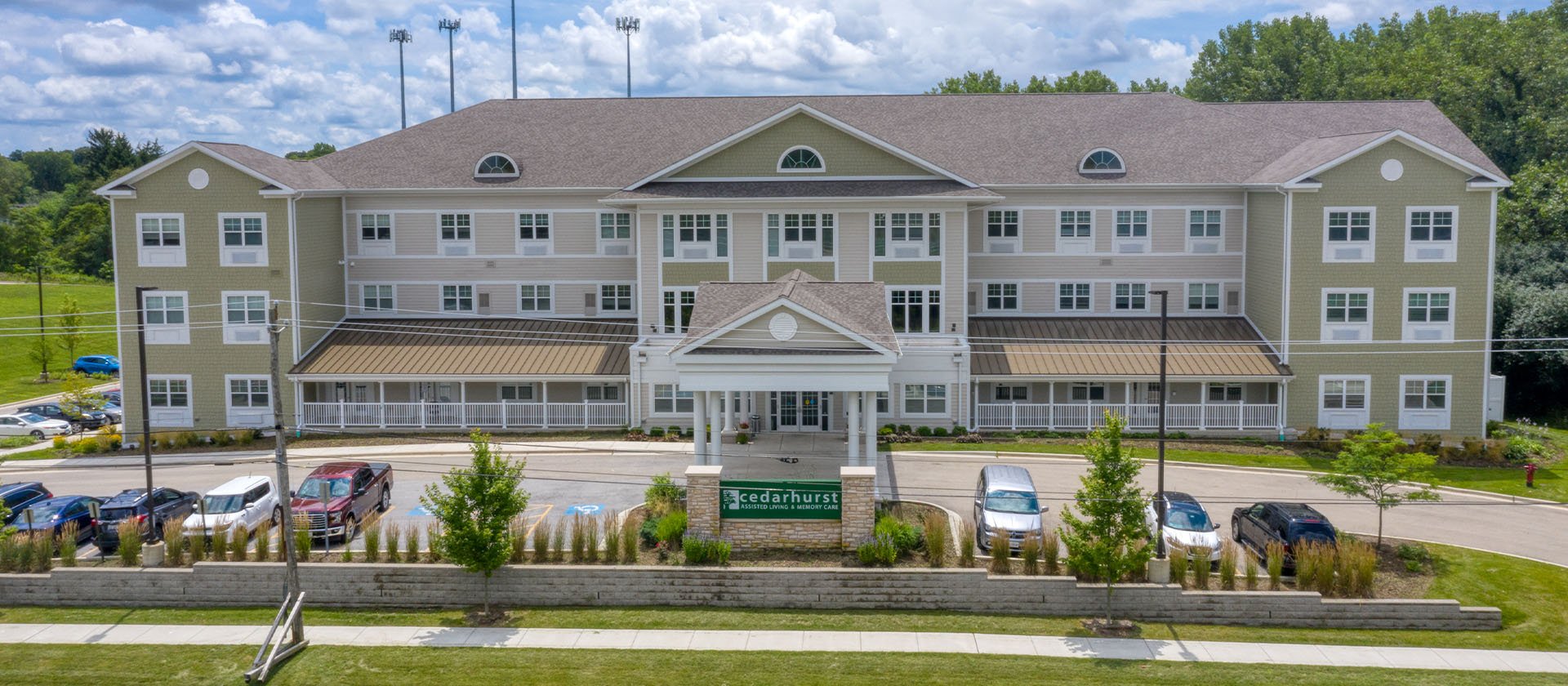 An inviting view of the Cedarhurst of Naperville senior living community from the outside, complete with the main building and its distinctive sign.