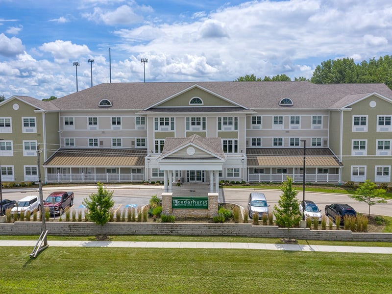 An inviting view of the Cedarhurst of Naperville senior living community from the outside, complete with the main building and its distinctive sign.