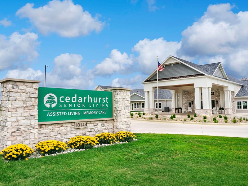 An inviting view of the Cedarhurst of Newburgh senior living community from the outside, complete with the main building and its distinctive sign.