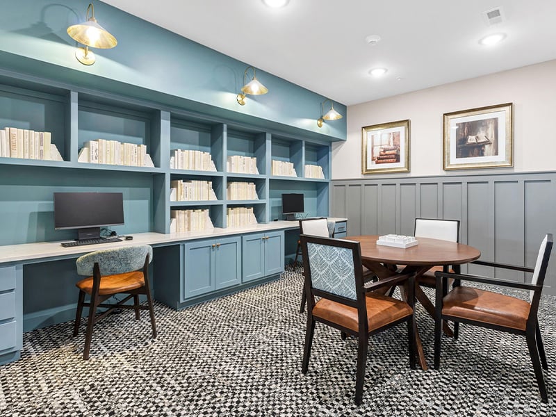 A welcoming, senior-friendly library at Cedarhurst of Newburgh with access to a computer and resources for reading and relaxation