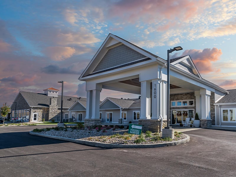 An inviting view of the Cedarhurst of Nicholasville senior living community from the outside, complete with the main building and its distinctive sign.