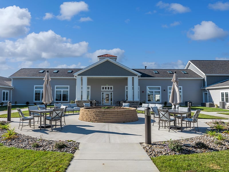 Outdoor green space at Cedarhurst of Nicholasville with paved walking paths and a raised garden bed.