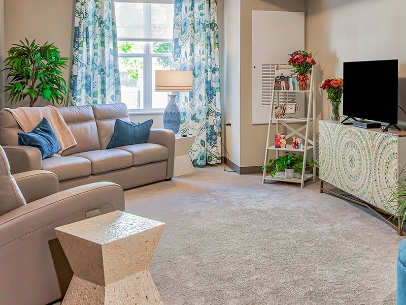Senior-friendly apartment living room at Cedarhurst of O'Fallon, offering comfortable and accessible design for residents