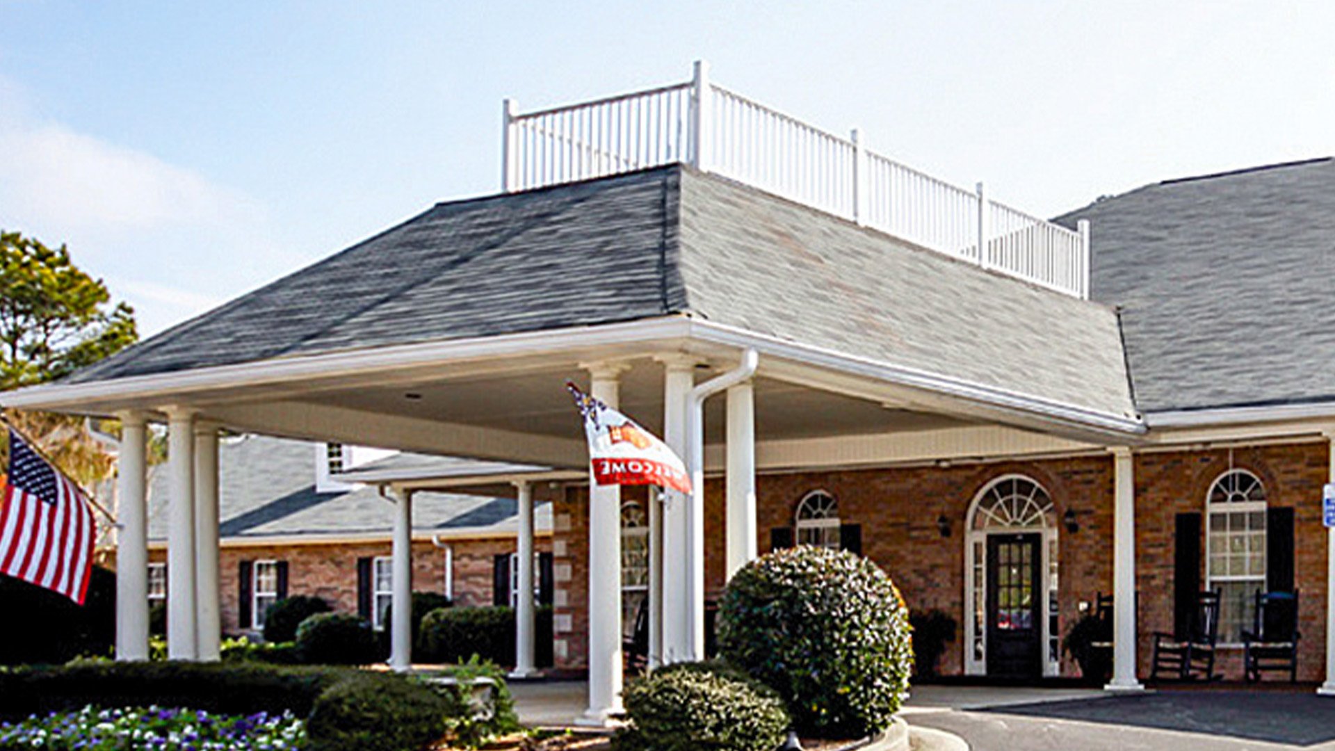An inviting view of the Cedarhurst of Oakwood senior living community from the outside, complete with the main building and its distinctive sign