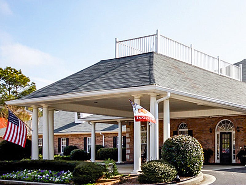 An inviting view of the Cedarhurst of Oakwood senior living community from the outside, complete with the main building and its distinctive sign
