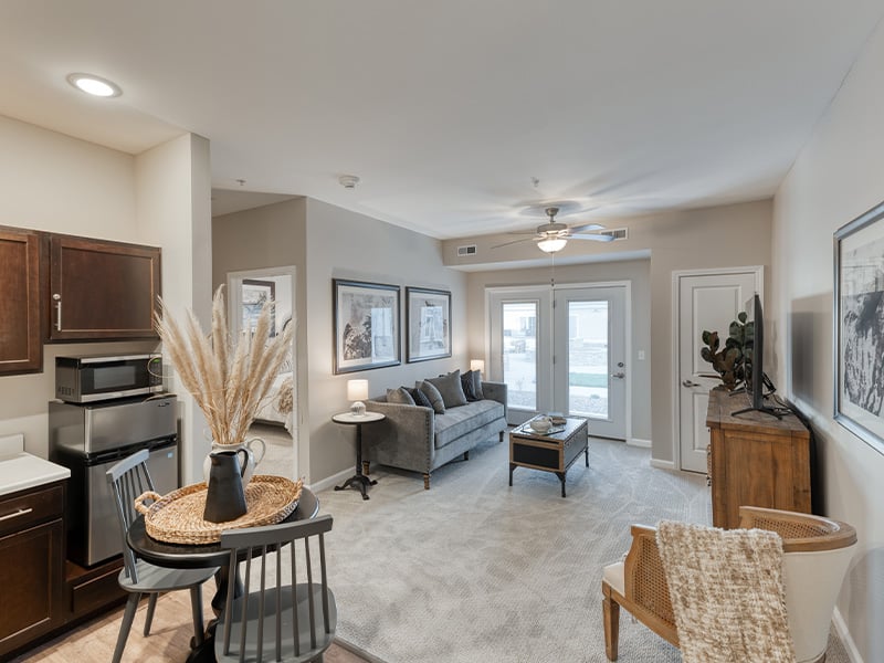 An apartment living room and kitchenette featuring accessible layouts and senior-friendly features at Cedarhurst of Owensboro.