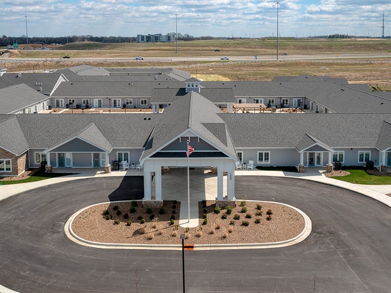 An inviting view of the Cedarhurst of Owensboro senior living community from the outside, complete with the main building and its distinctive sign.