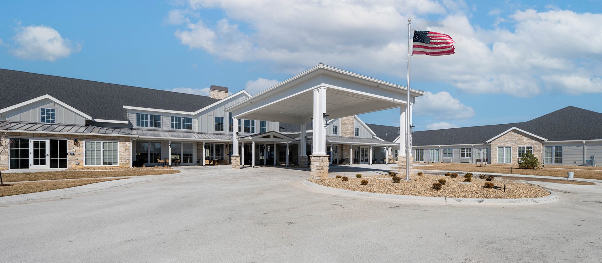 An inviting view of the Cedarhurst of Salina senior living community from the outside, complete with the main building and its distinctive sign
