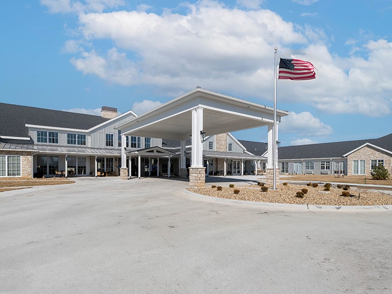 An inviting view of the Cedarhurst of Salina senior living community from the outside, complete with the main building and its distinctive sign