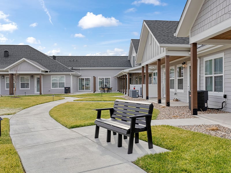 Outdoor green space at Cedarhurst of Salina with paved walking paths