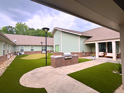 Outdoor courtyard space at Cedarhurst of Spartanburg with paved walking paths and comfortable seating.